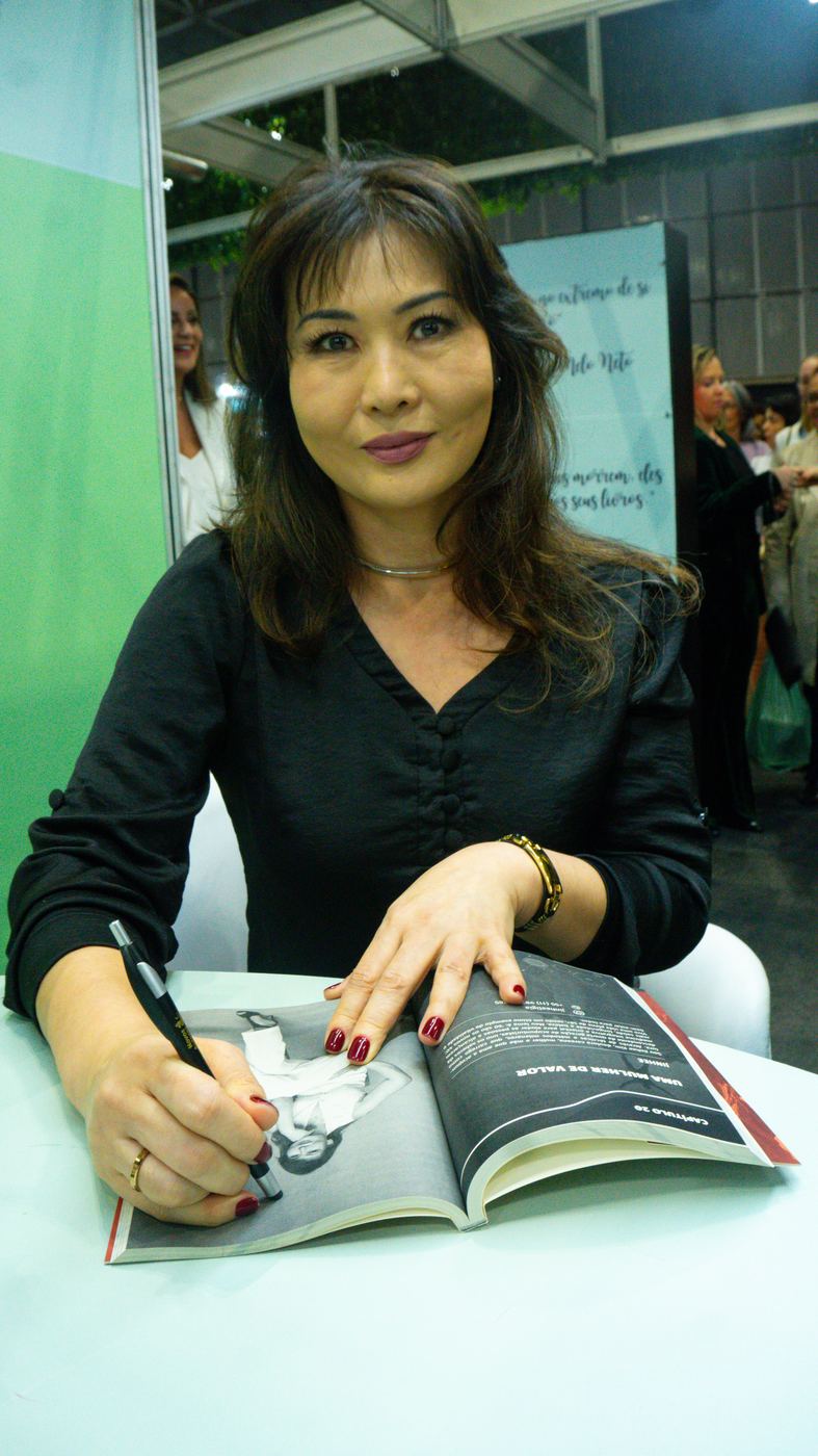 Autora autografando seu livro na Bienal